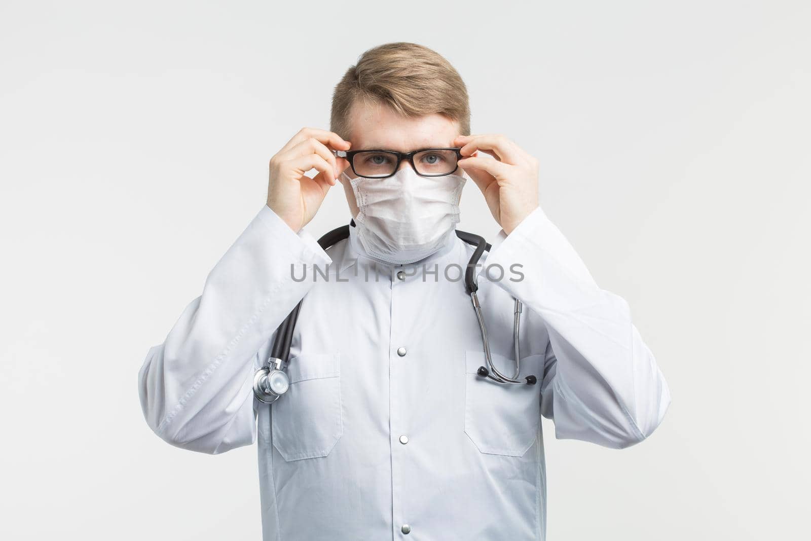 Health and medicine - doctor wearing the stethoscope and white mask on white background.