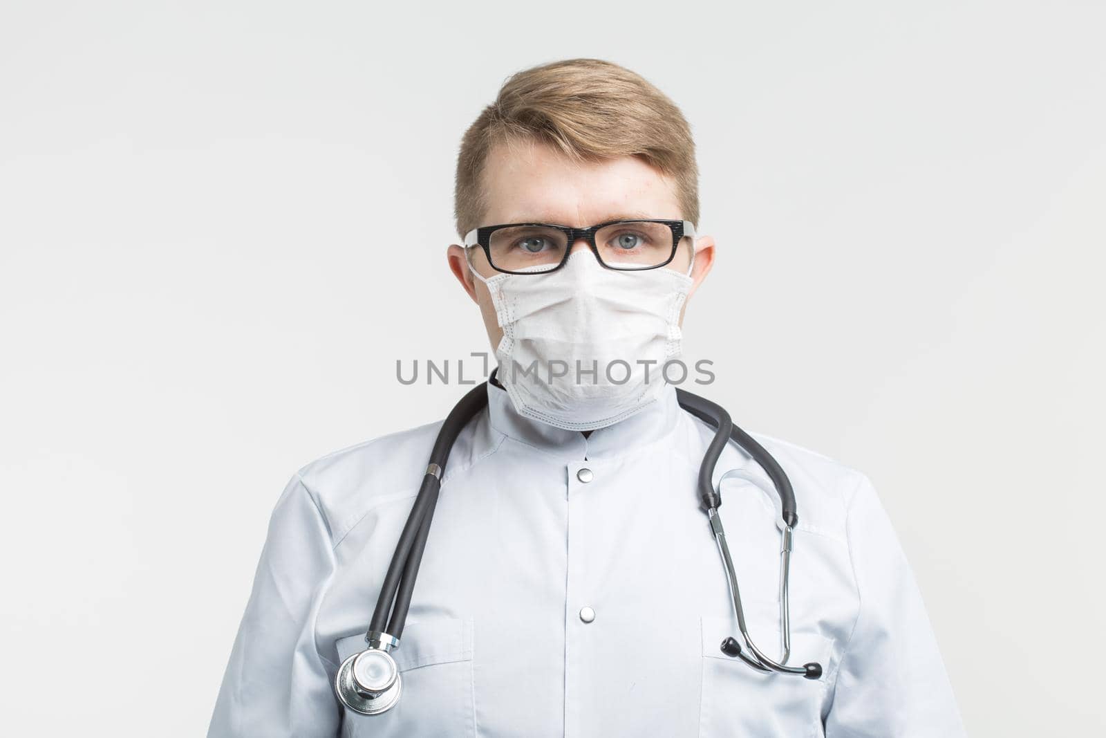 Health and medicine - doctor wearing the stethoscope and white mask on white background.