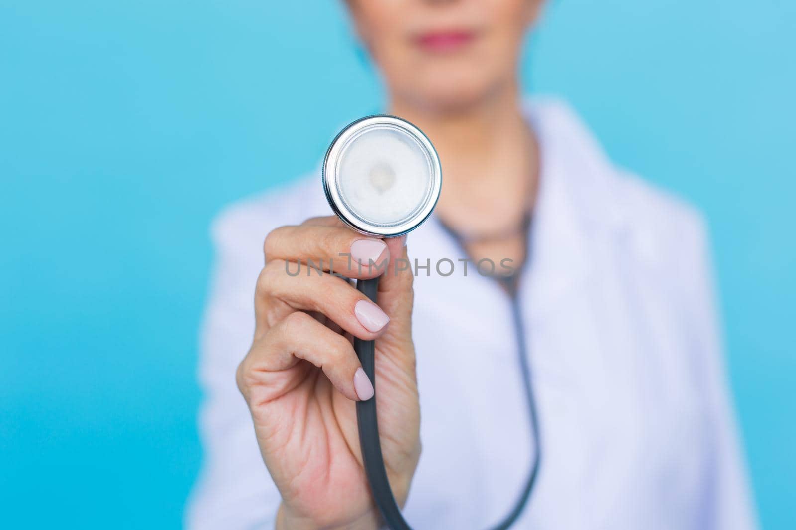 Doctor with stethoscope, close up over blue background by Satura86