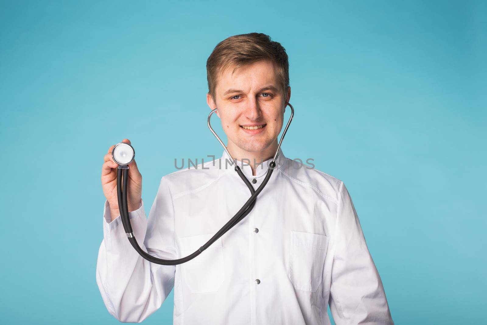 Doctor with stethoscope showing thumbs up over blue background by Satura86