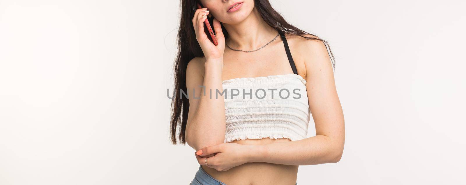Technology and people concept - Close up of young woman talking on cellphone on white background with copy space by Satura86