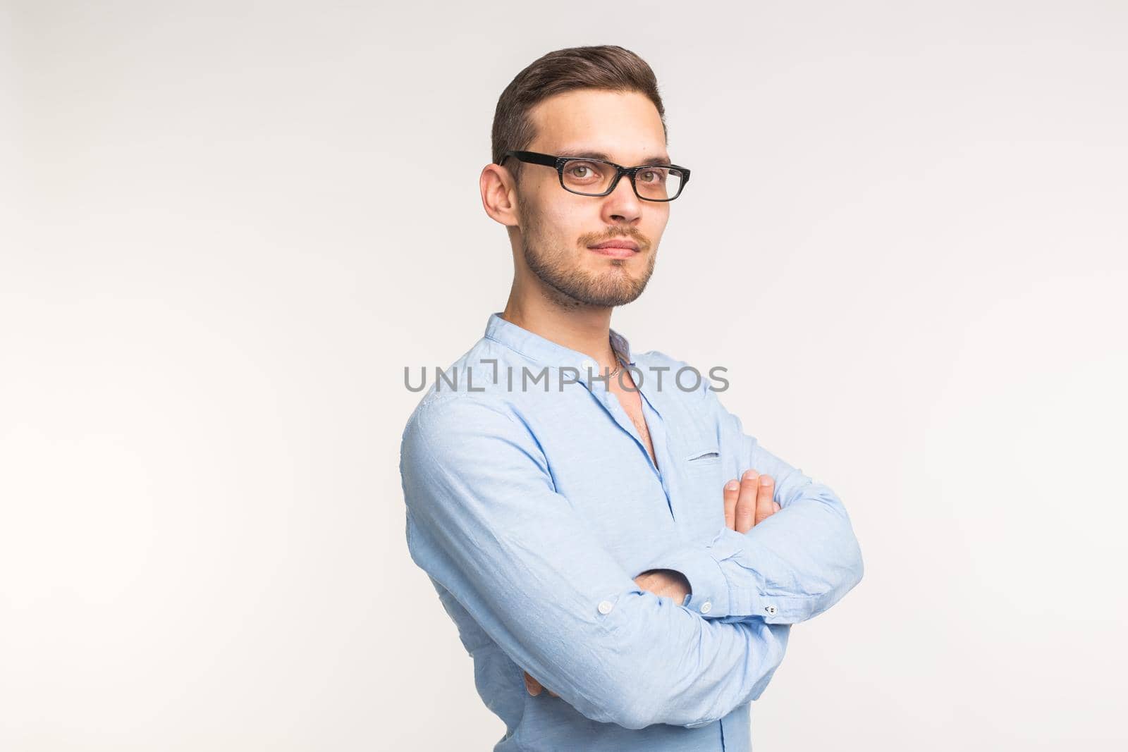 Business and people concept - Handsome man in black glasses over white background, arms crossed.