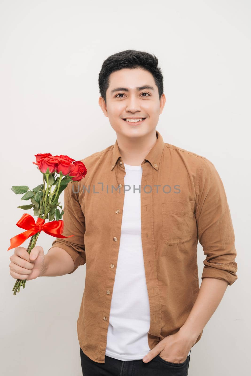 Smiling Asian man holding bunch of roses. 