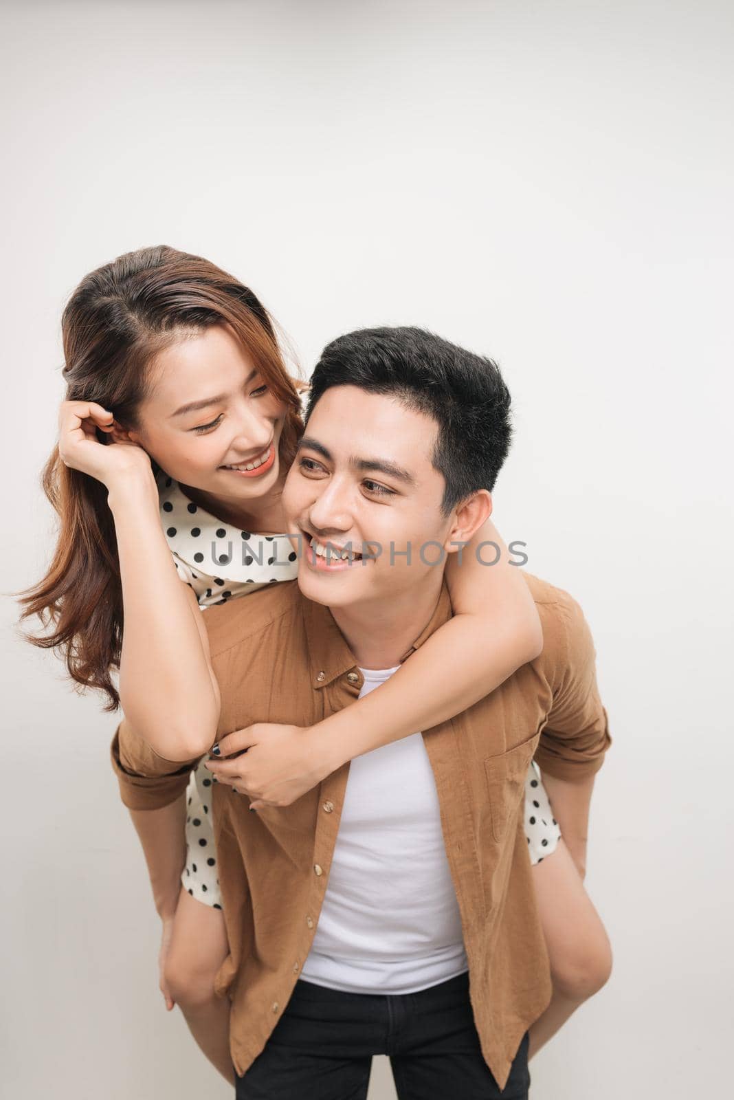 man carrying his lover on back, woman showing peace symbol over white background