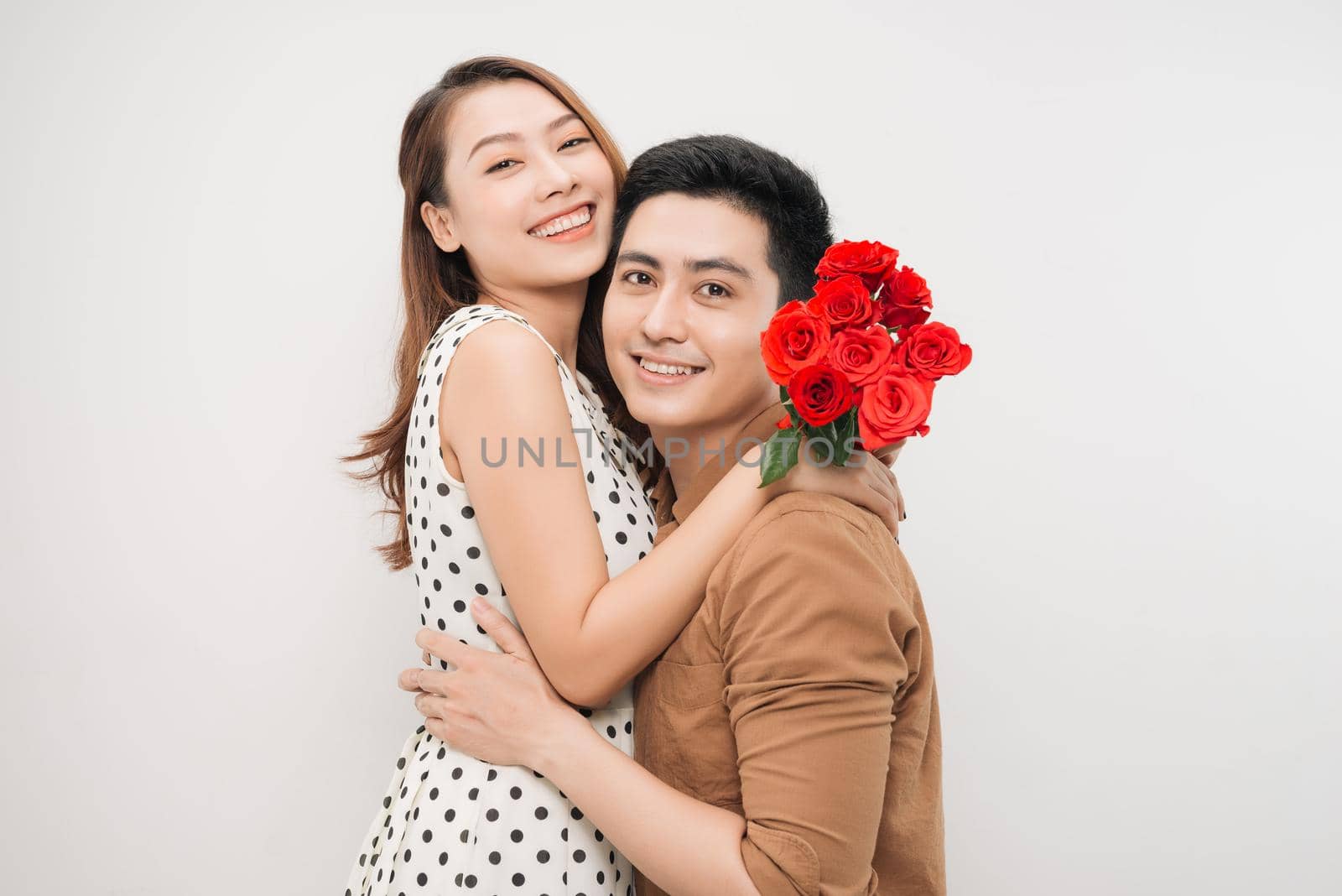 Portrait of cheerful lovely cute couple with beaming smiles hugging and looking to each other,