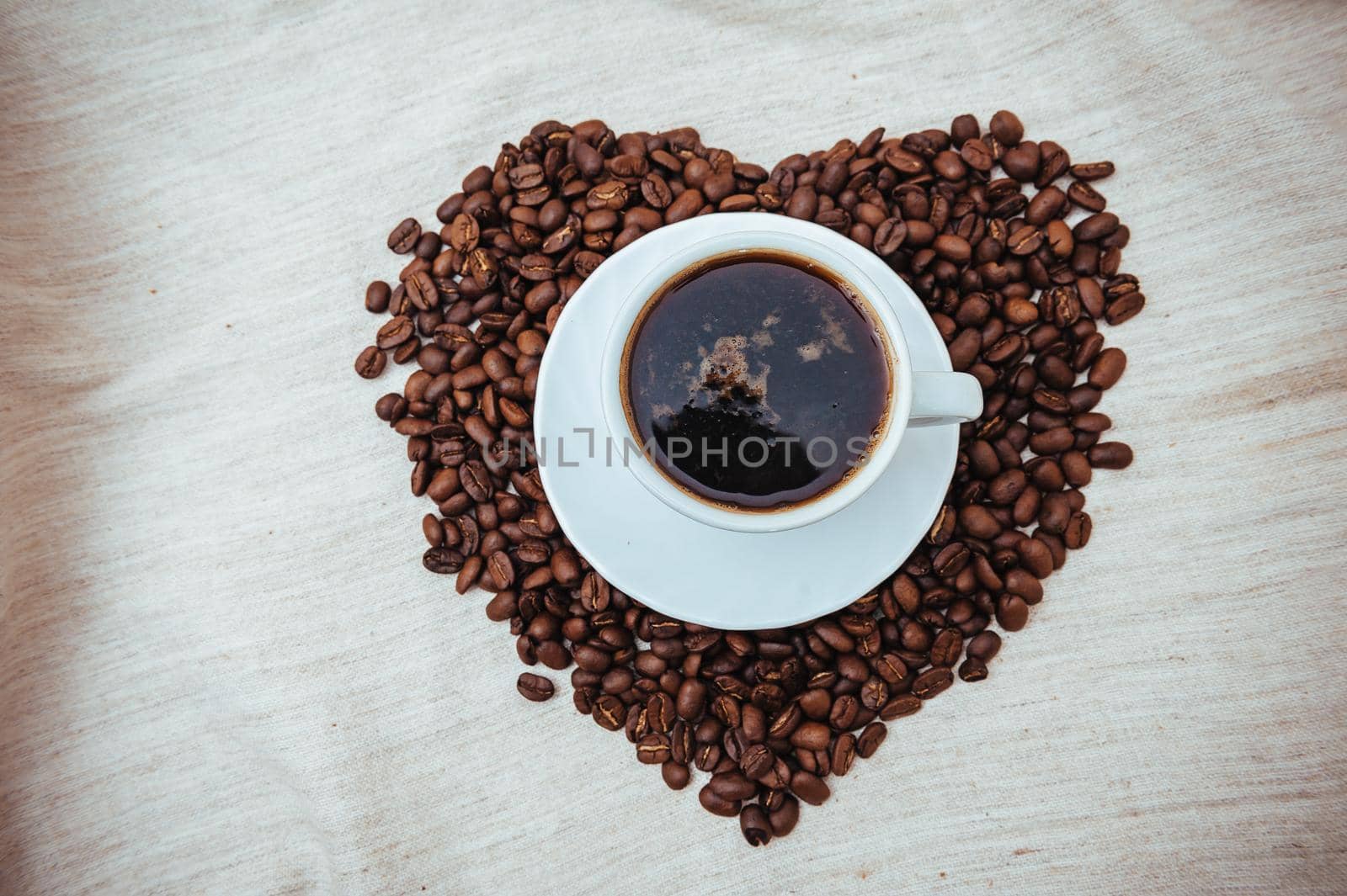 Cup of Coffe. Coffee beans in shape of heart. coffee beans isolated on white background. roasted coffee beans, can be used as a background. by Andrii_Ko