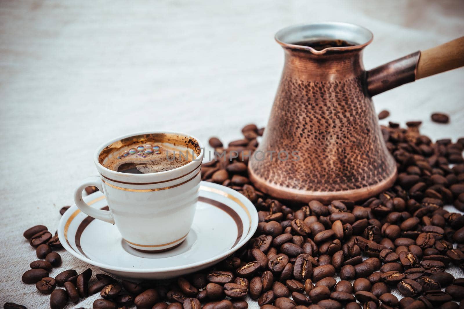 Coffee turk and cup of coffee on burlap background. coffee beans isolated on white background. roasted coffee beans