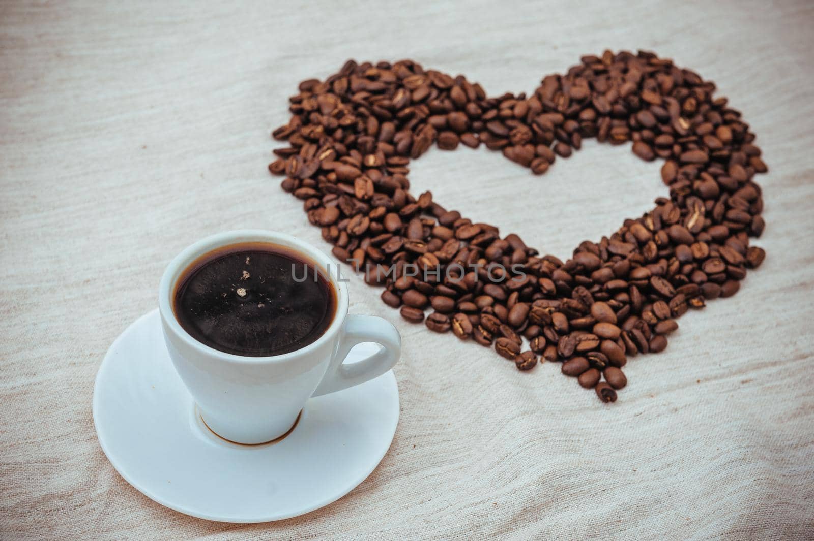 Cup of Coffe. Coffee beans in shape of heart. coffee beans isolated on white background. roasted coffee beans, can be used as a background. by Andrii_Ko