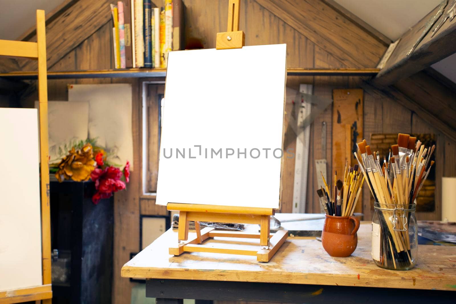 Artistic equipment in a artist studio: empty artist canvas on wooden easel and paint brushes Retro toned photo copy space space for text
