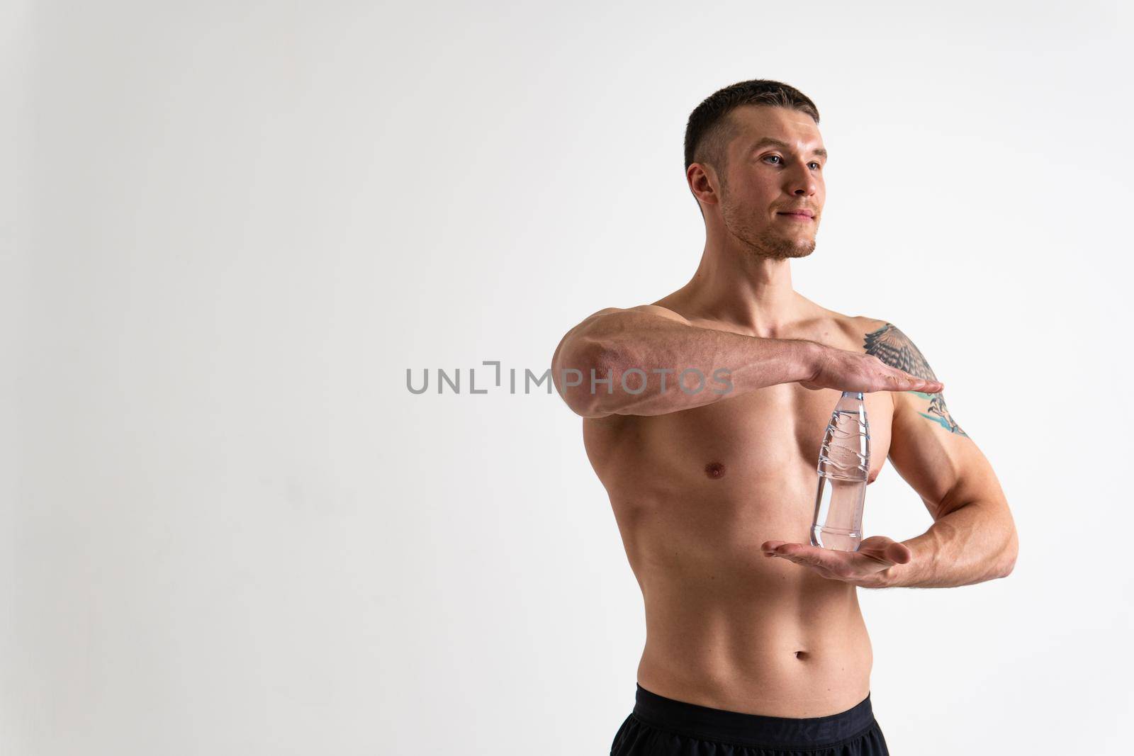 Male drink-water fitness is pumped with a towel on a white background isolated strong muscular training male bottle guy, muscles athletic. Towel copy pace, sportsman one muscle by 89167702191