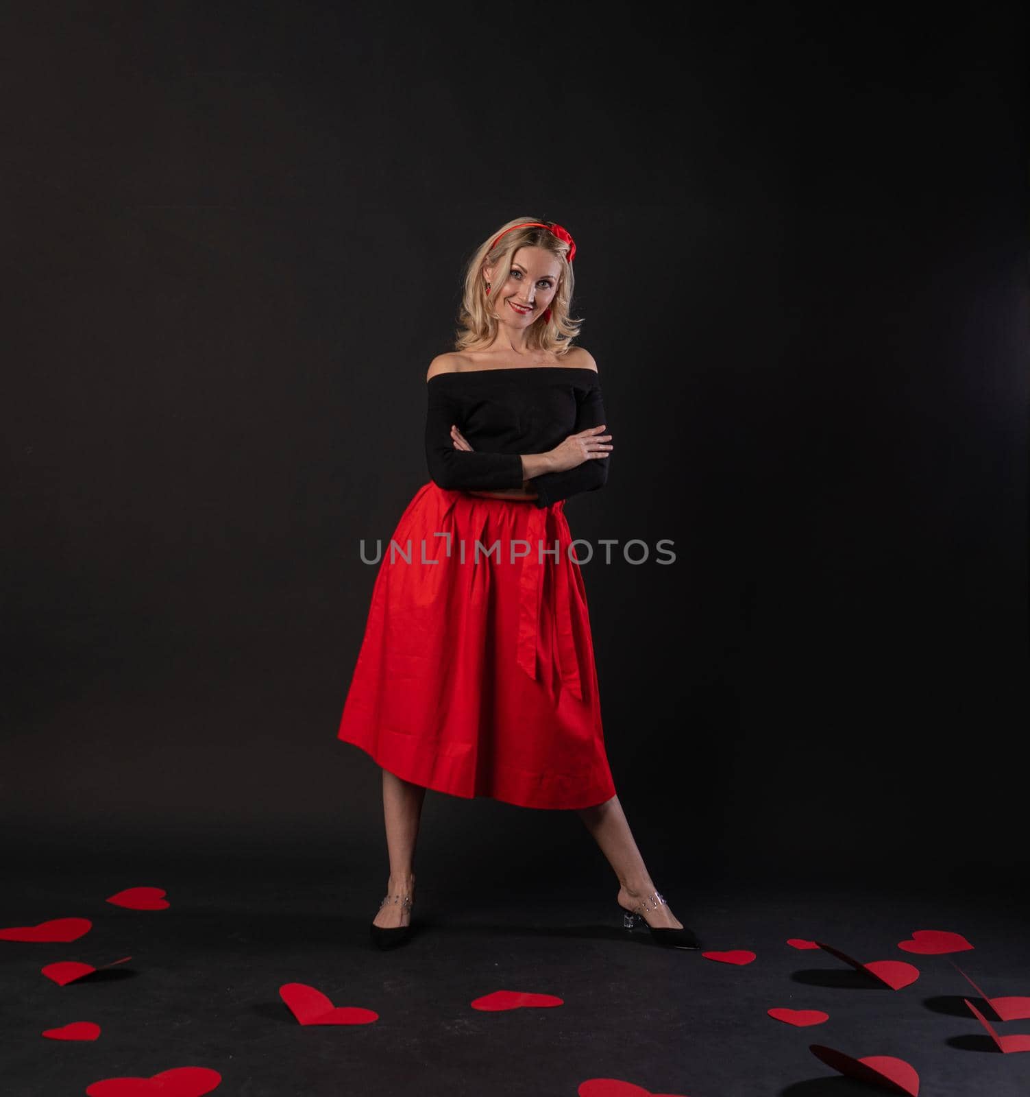 Girl standing around cardboard hearts happy symbol, Valentine, on the floor hearts lovely romance. holiday. love the feeling of black in the red dress girl, barefoot