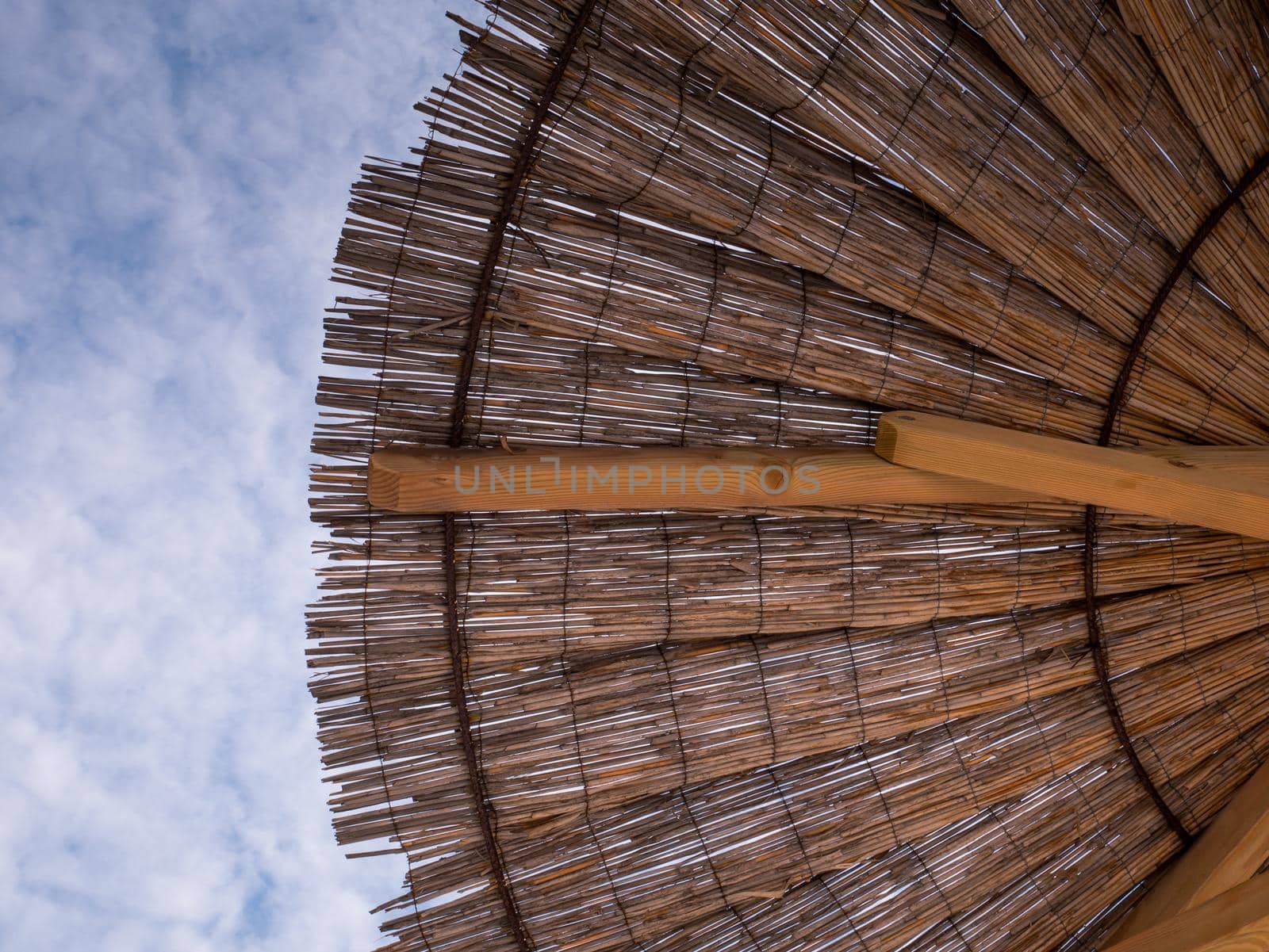 Part of the straw beach umbrellas and View of the beautiful blue sky with little clouds