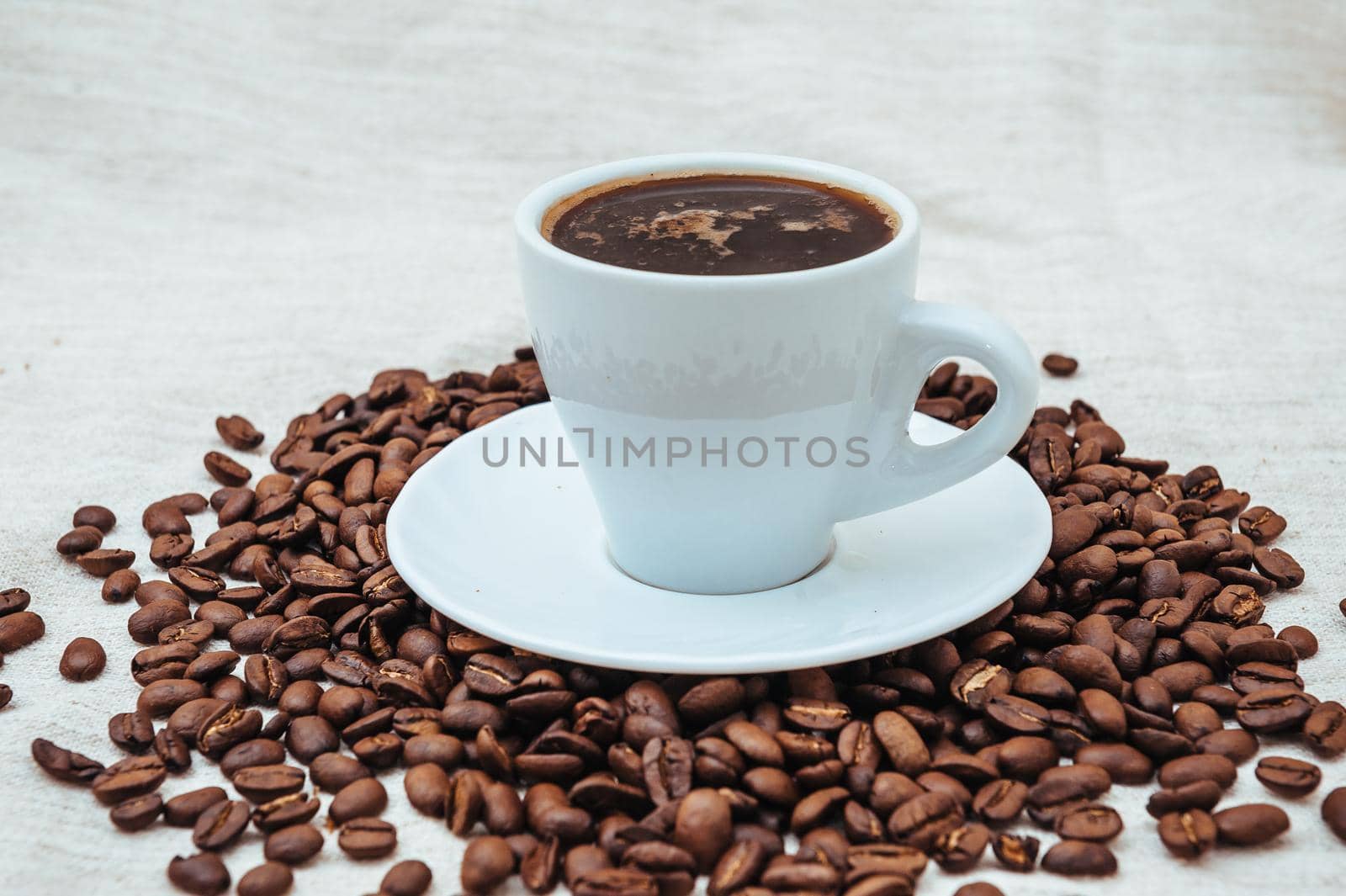 Cup of coffee and coffee beans on beige background