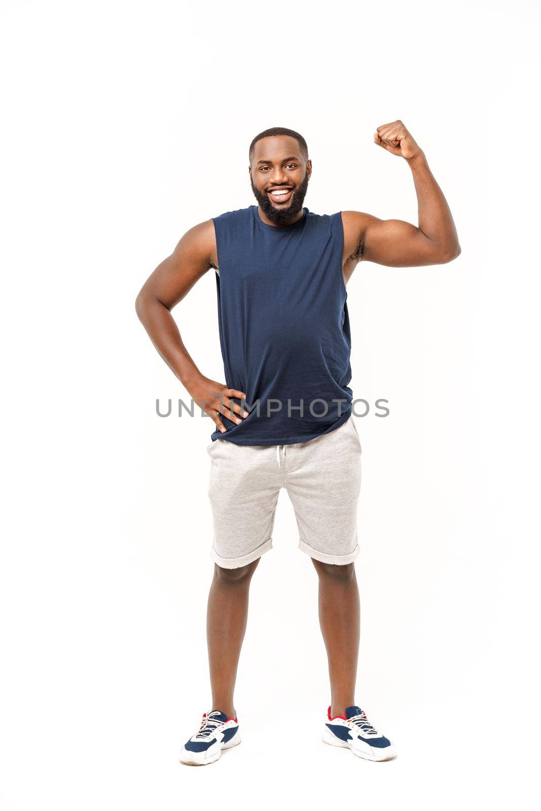 African American teenager shows muscles on arm. Isolated on white background. Studio portrait. Transitional age concept by Benzoix