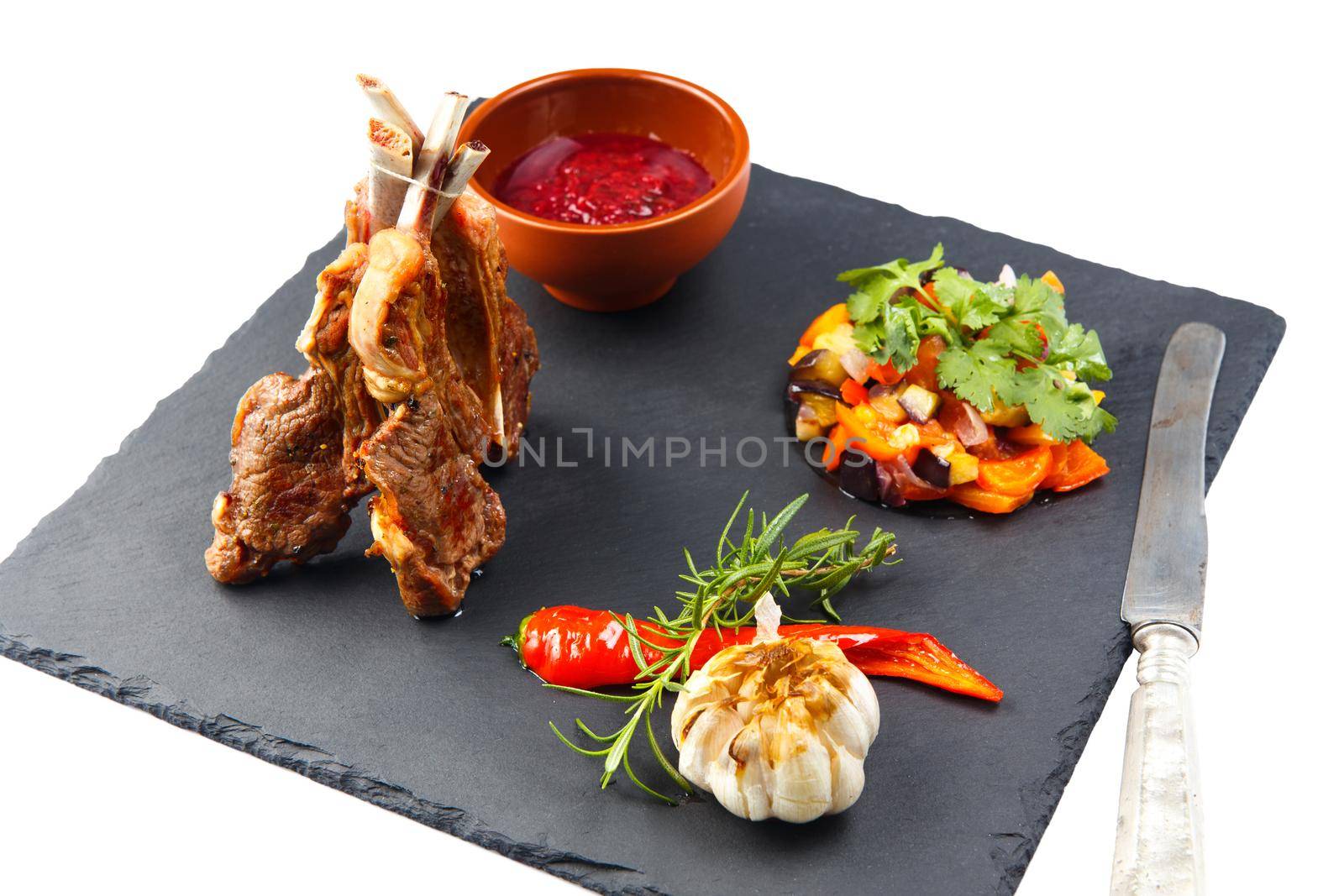 Rack of lamb with tkemali sauce and vegetable Ratatouille. Selective focus. Isolated on white.