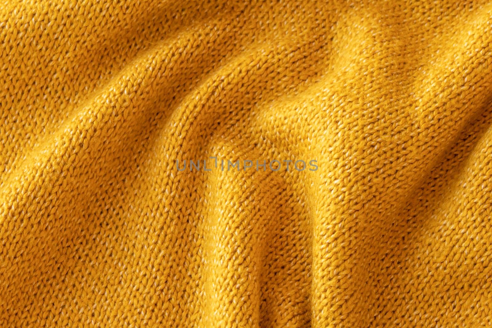 Soft knitted yellow sweater texture closeup. Light orange abstract background by lavsketch