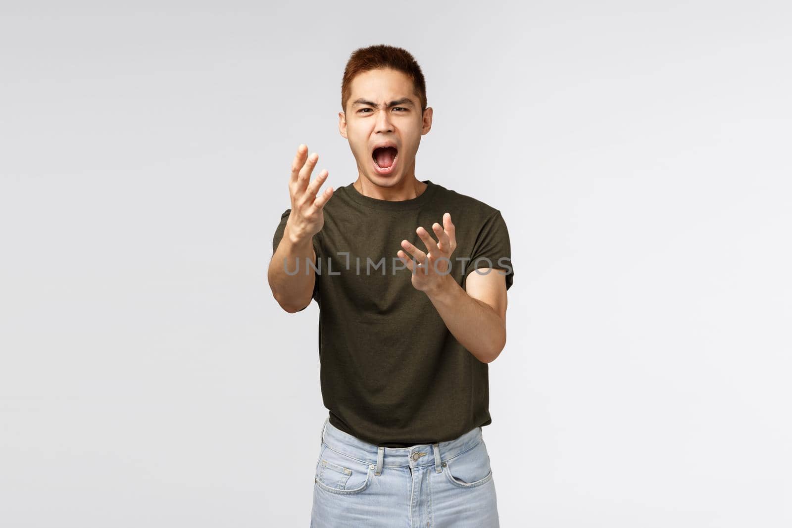 Portrait of unhappy asian man shaking hands, look with regret, being heartbroken or very upset about failure, losing prize, complaining, express his frustartion, grey background.