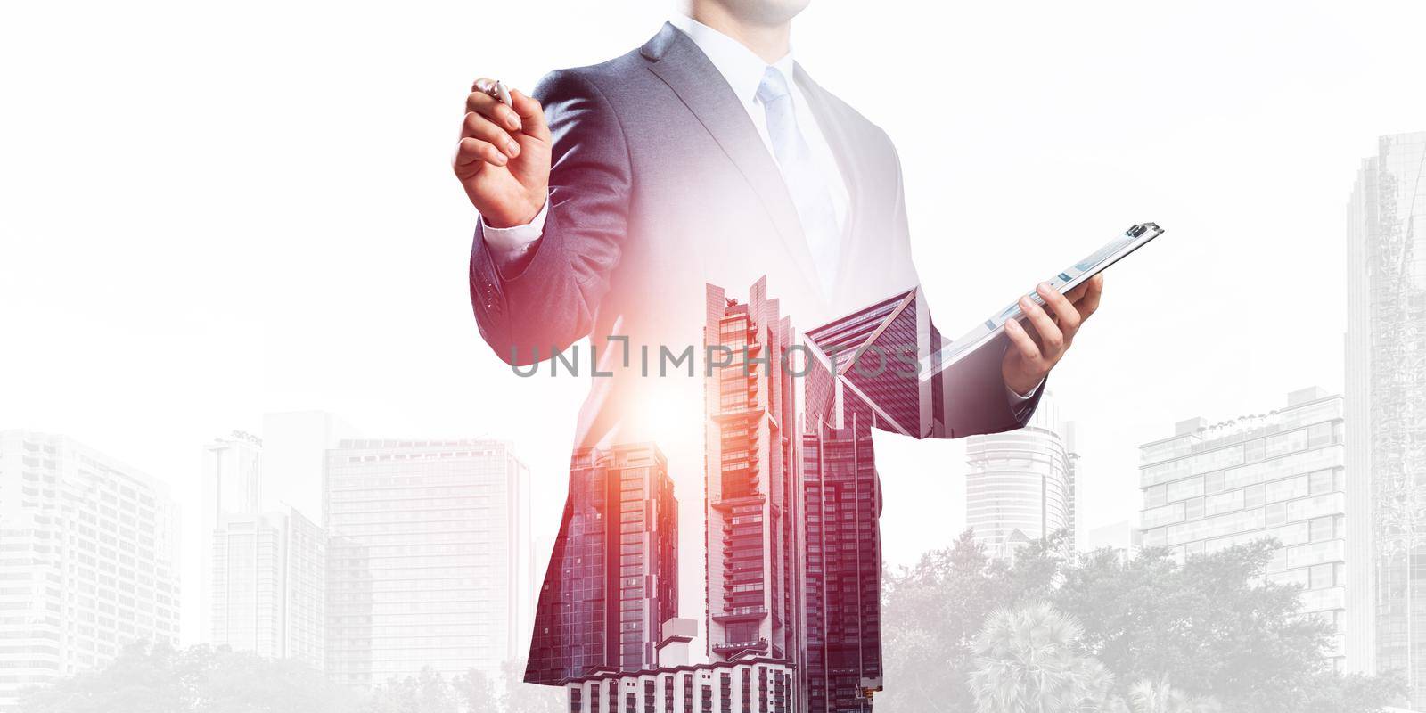 Double exposure businessman pointing on empty space and downtown cityscape. Standing consultant in business suit and tie without face. Blank copy space ready for business presentation