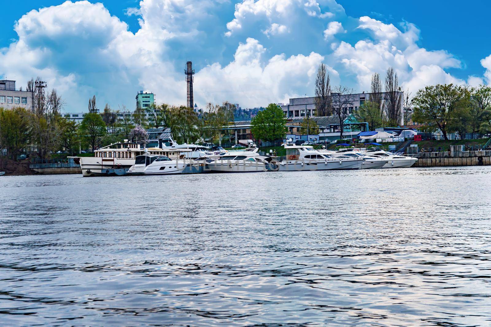 Mooring place for river pleasure boats on the Dnieper River. Parking place for boats. Ship pier. Bank of the river. Coastline. Water transport. Dnieper river in Kiev. Water stream.