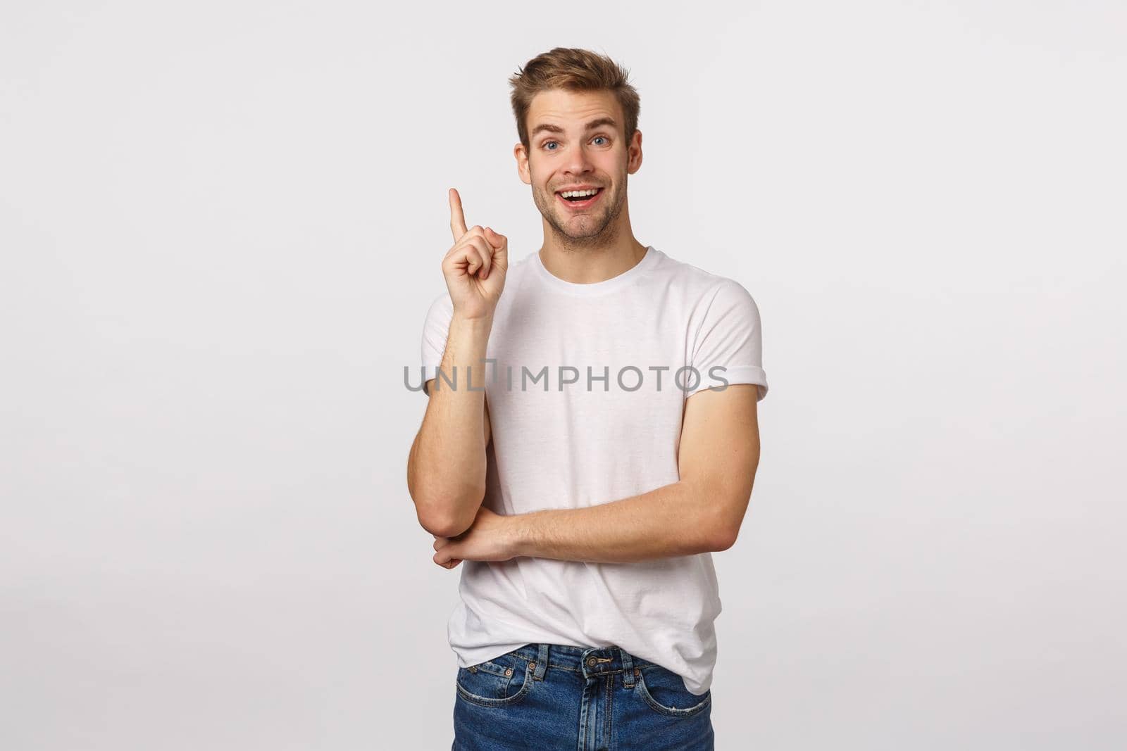 Hear me out, excellent idea striked me. Attractive happy smiling blond guy in white t-shirt, raise index finger eureka gesture and grinning, add suggestion, have plan, standing white background by Benzoix