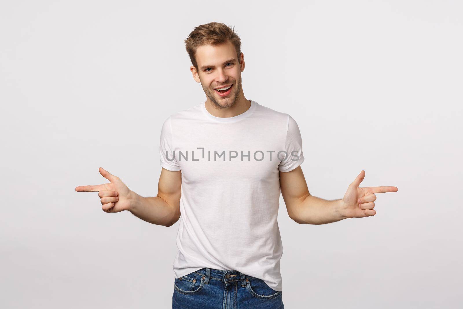 Have a look at this two. Attractive sassy macho man with bristle, blond hair, suggest choices, pointing sideways, indicate left and right banners with products and smiling pleased, white background.