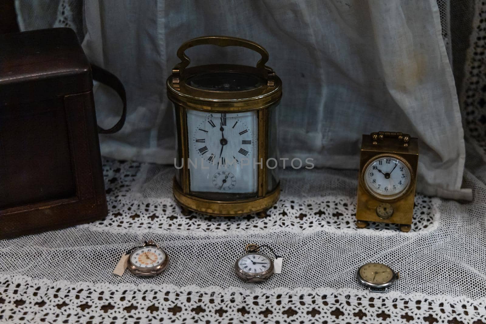 Very old retro standing clocks with few lying on table