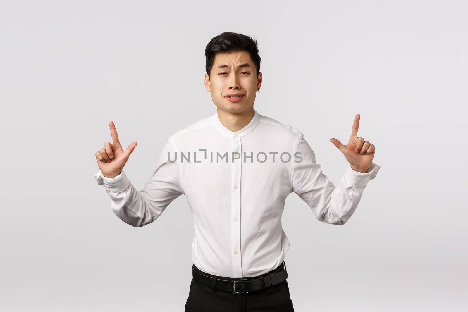 Asian cute boyfriend feeling scared, acting like coward or silly person, pointing up, grimacing worried, hesitating and having doubts, standing indesicive, anxiously thinking how come up to girl.