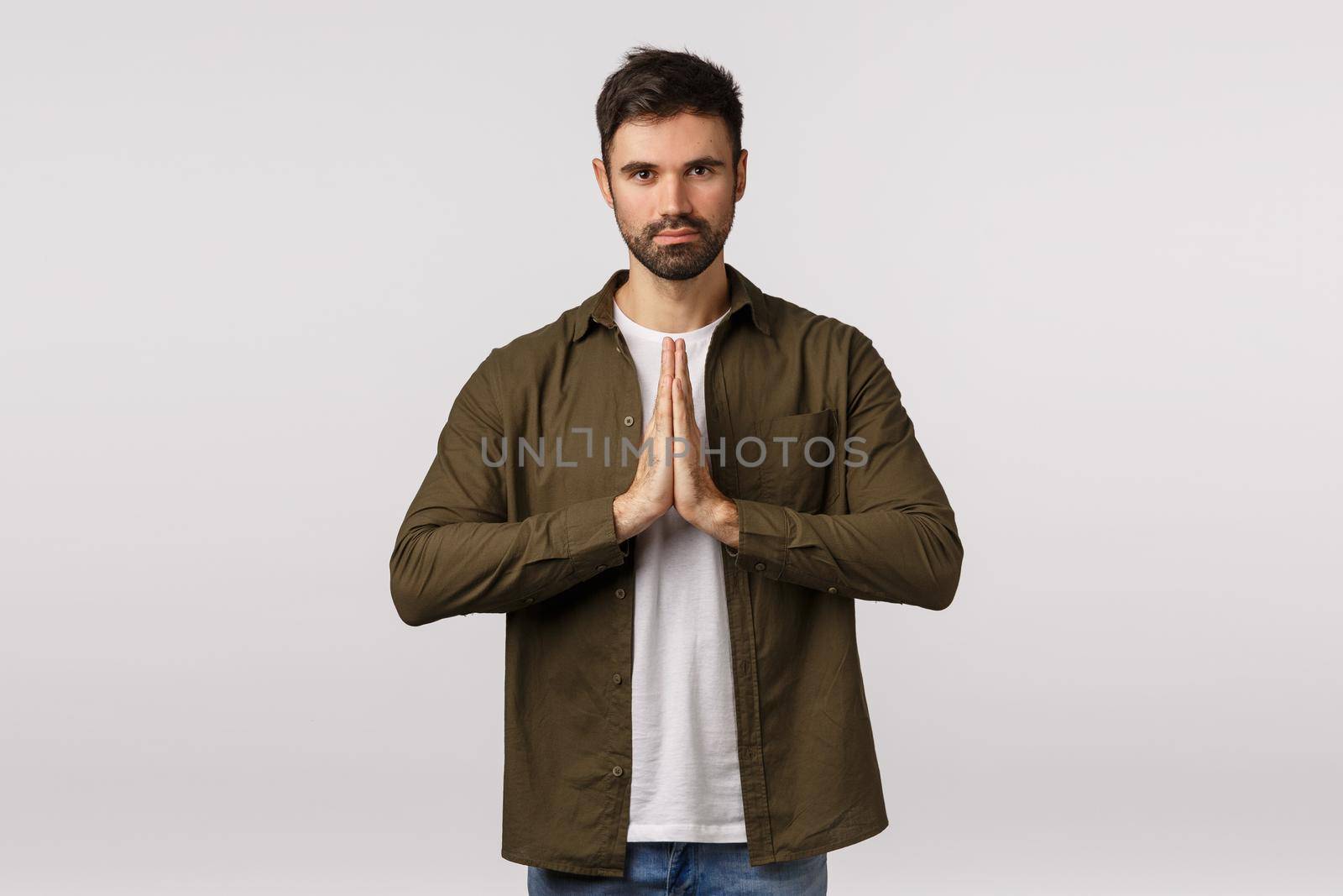 May the force be with you. Confident and patient good-looking bearded man practice yoga, press palms together in namaste, praying gesture smiling peaceful and relaxed, meditating, bowing politely by Benzoix