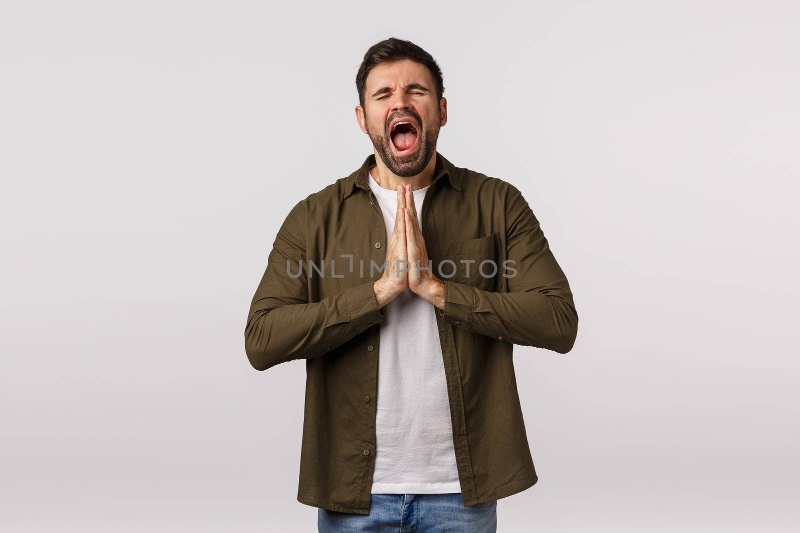 Please forgive me im begging you. Miserable and upset, sad bearded man crying and beg apology, close eyes press palms together in pray gesture, supplicating, being sad and frustrated.