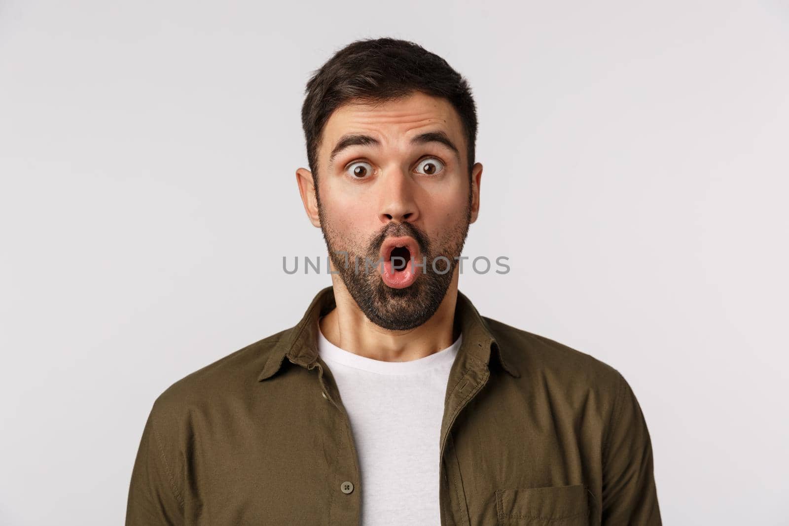 Amazement, emotions and people concept. Close-up astonished, fascinated man in awe, with beard, folding lips gasping speechless and amazed, see thing he wanted with large discount, white background.