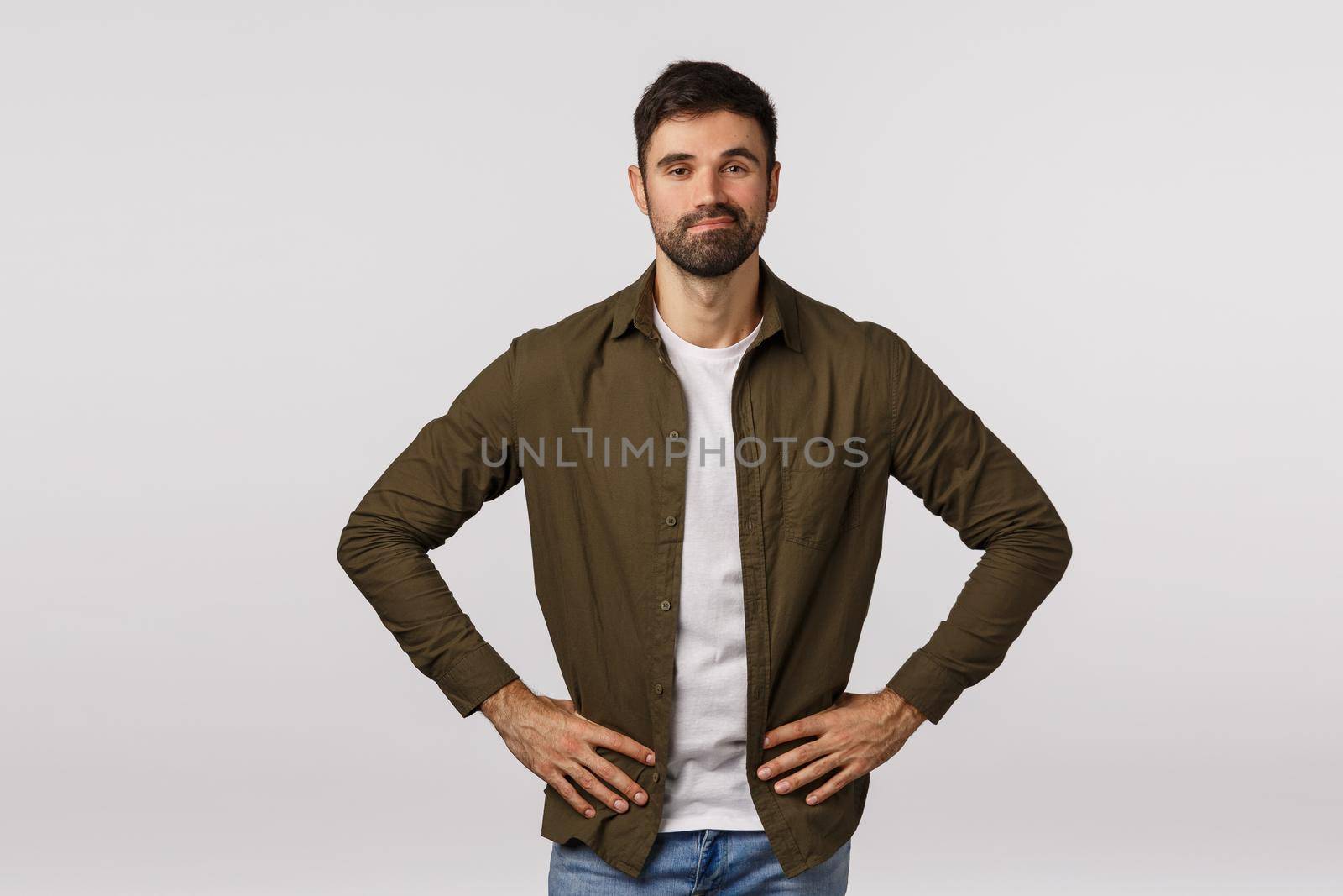 Proud and confident, motivated lucky businessman manage great business, hold hands on hips and smiling satisfied, revise good result, feeling pleased, standing white background joyful.