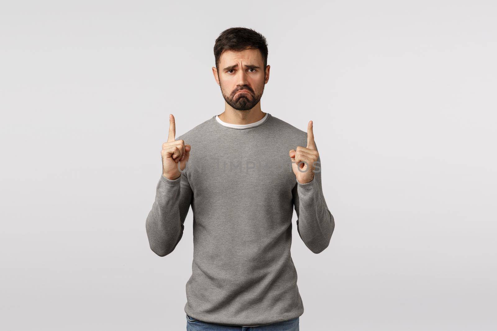 Miserable, upset and unsatisfied grumpy caucasian bearded guy, wear grey sweater, pointing up upset and distressed, feel regret or complain bad event happened, standing disappointed white background by Benzoix
