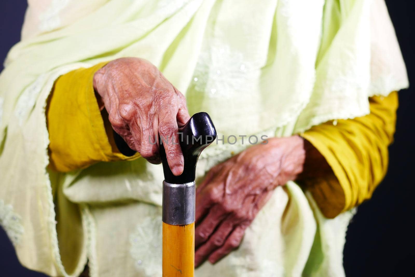 senior women hands on walking stick
