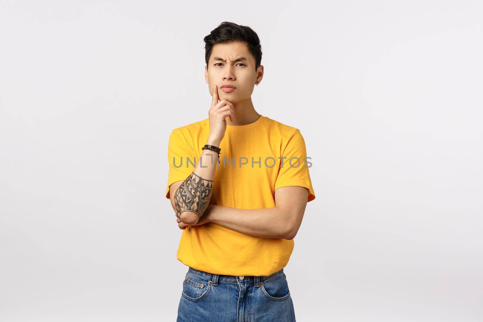 Hmm, I need to think about it. Serious-looking focused smart asian young man, making difficult choice, thinking, touching chin frowning and staring pensive, standing thoughtful, white background by Benzoix
