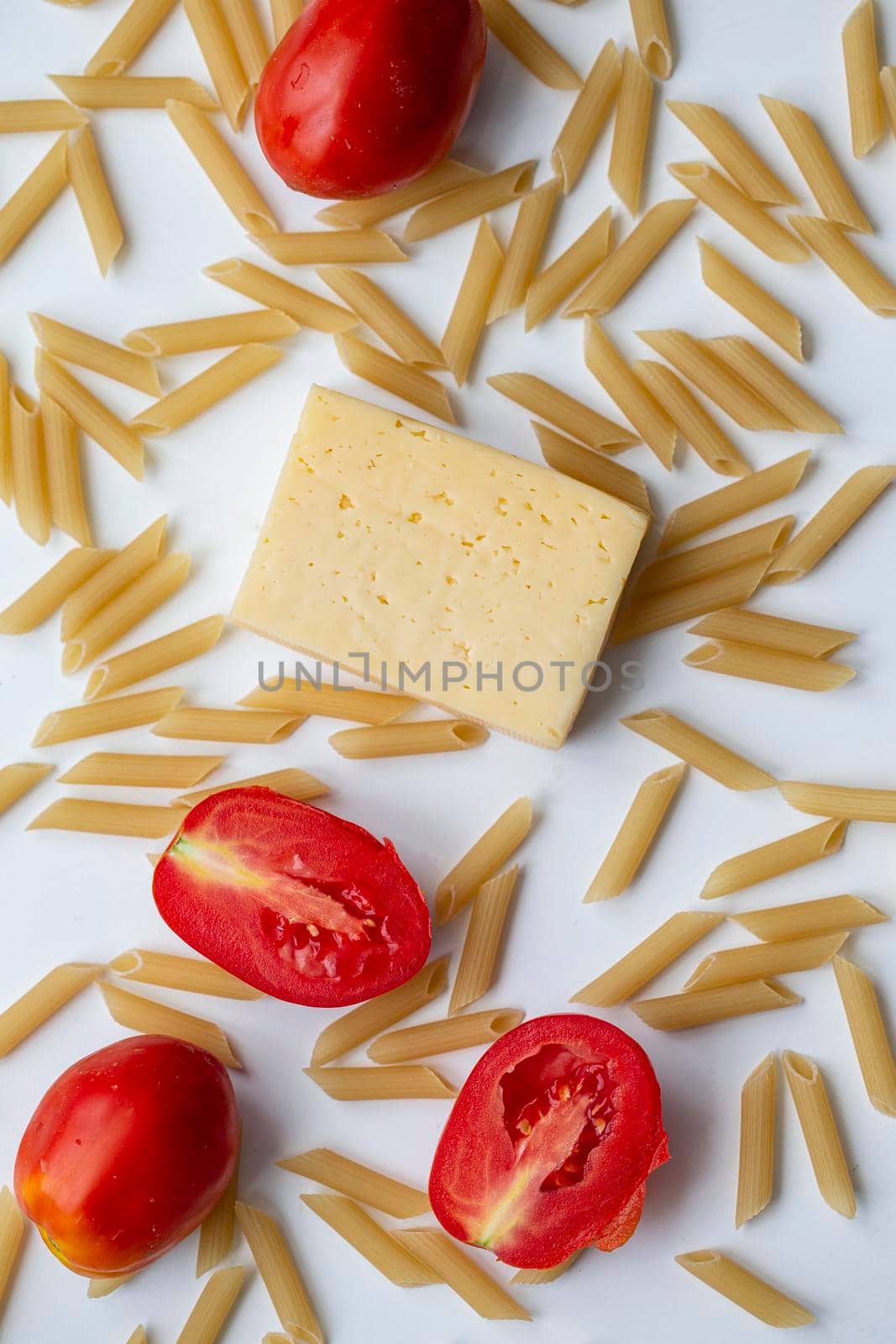 Tomatoes a piece of cheese pasta on a white background close-up