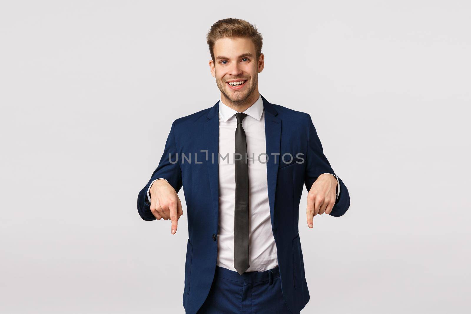 Here is what you need. Handsome stylish happy businessman, blond bearded guy in classic suit, invite check out promo, pointing fingers down and smiling, have interesting corporate banner for you see by Benzoix