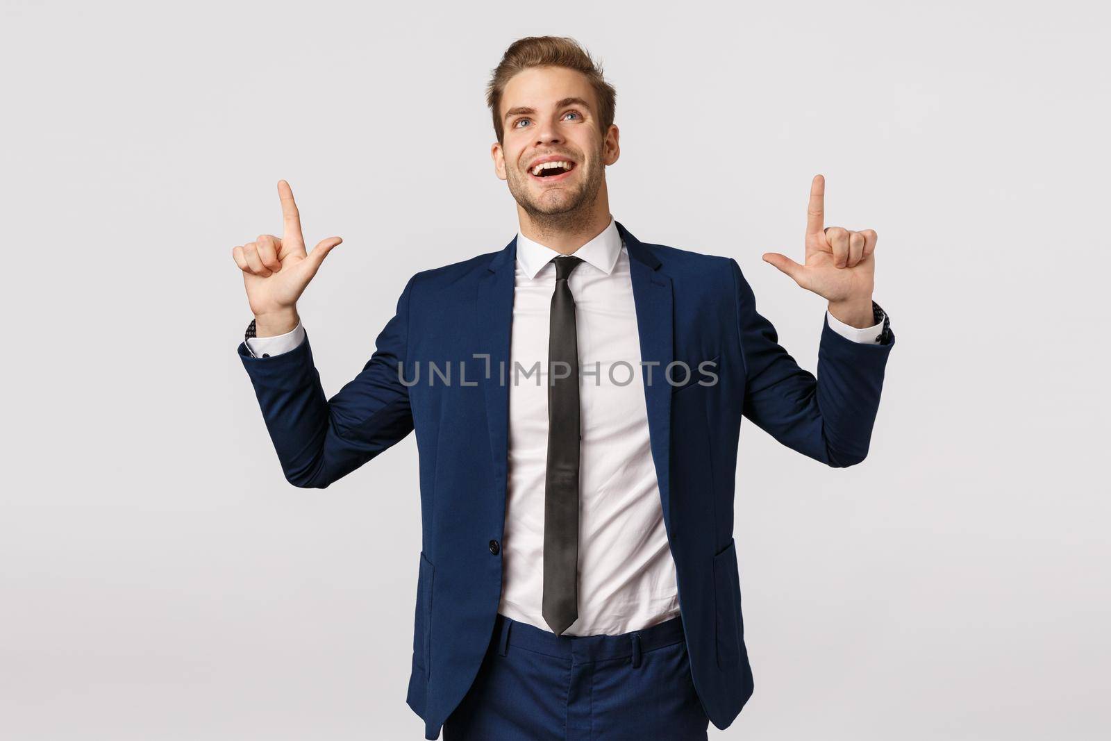 Dreamy, optimistic businessman seeing prosperity chance, smiling and looking up excited, contemplate beautiful scenery, captured attention on product promo, standing glad white background by Benzoix