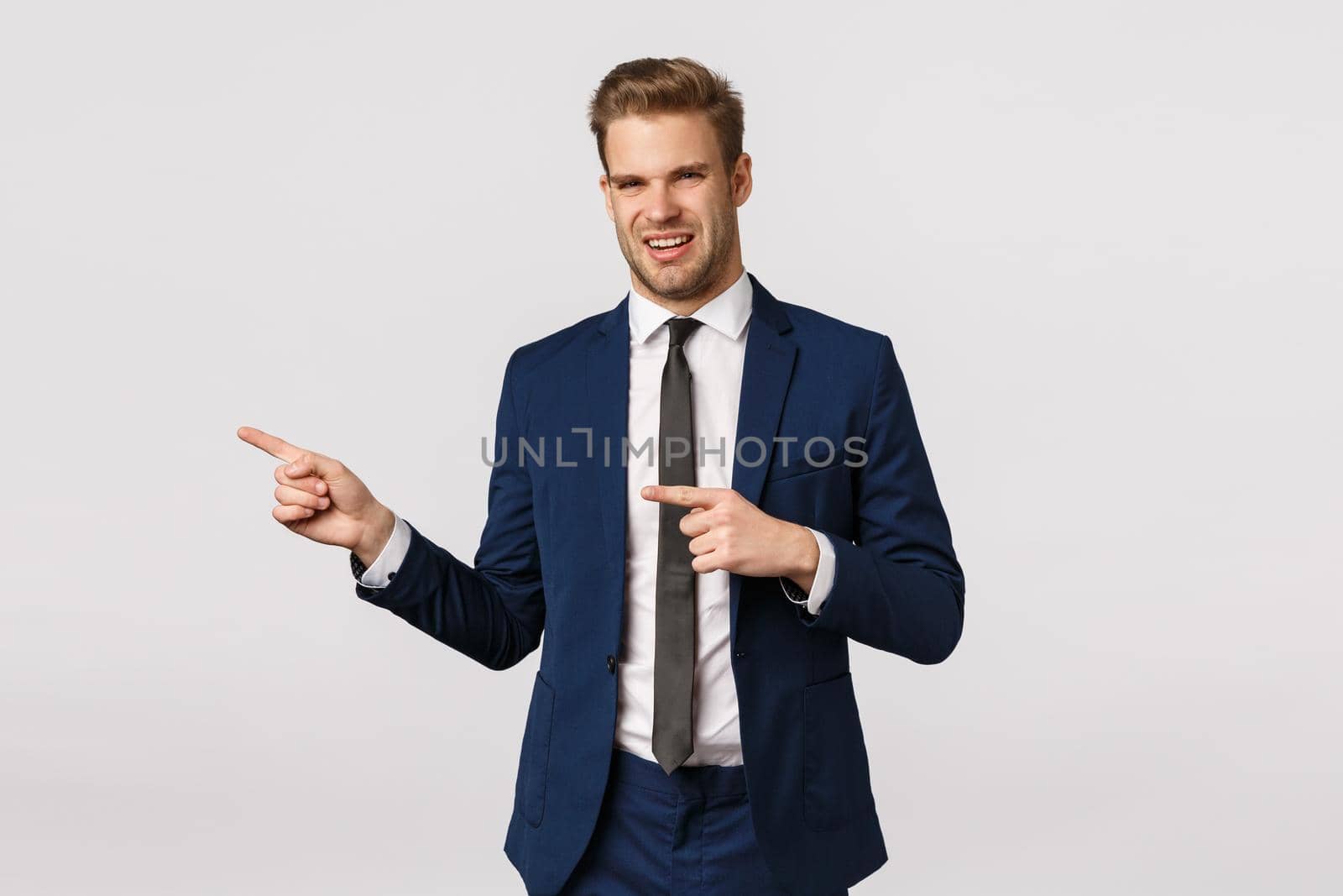 Eeew thats gross. Displeased businessman feeling aversion, seeing unappropriate, disgusting thing, pointing left, grimacing, cringe bothered and unsatisfied, standing white background.