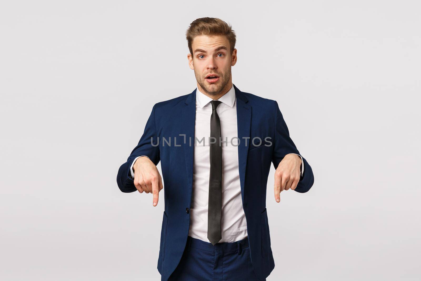 Curious and questioned young newbie consulting manager, asking advice, pointing down to ask question about interesting product, Good-looking handsome businessman have something offer.
