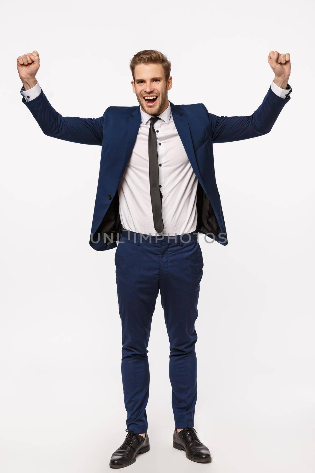 Congratulations we signed important contract. Vertical full-length shot cheerful successful businessman in suit, raising hands up, fist pump and smiling cheerful, celebrating victory, triumphing by Benzoix