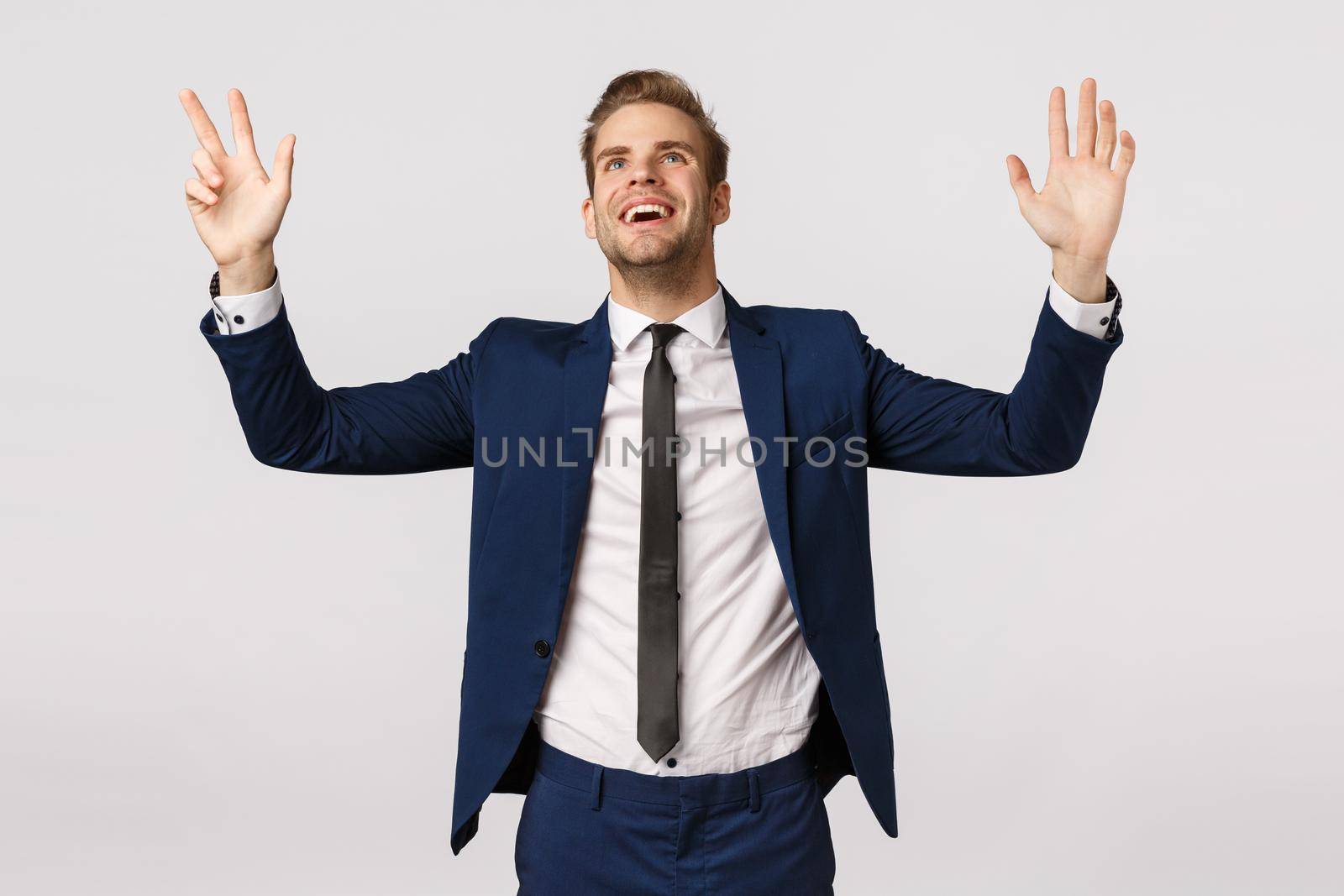 Hallelujah I got promoted. Pleased and relieved, thankful successful young blond male entrepreneur in classic suit, raising hands sky, look up thanking god pleased, express gratitude white background.