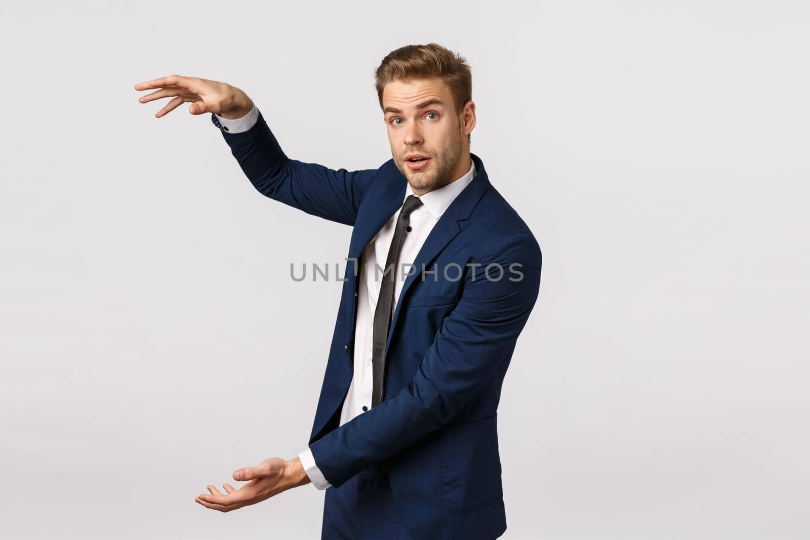 Attractive blond bearded businessman, male entrepreneur discuss business, having meeting and shaping something big over white background, consulting clients, standing white background.