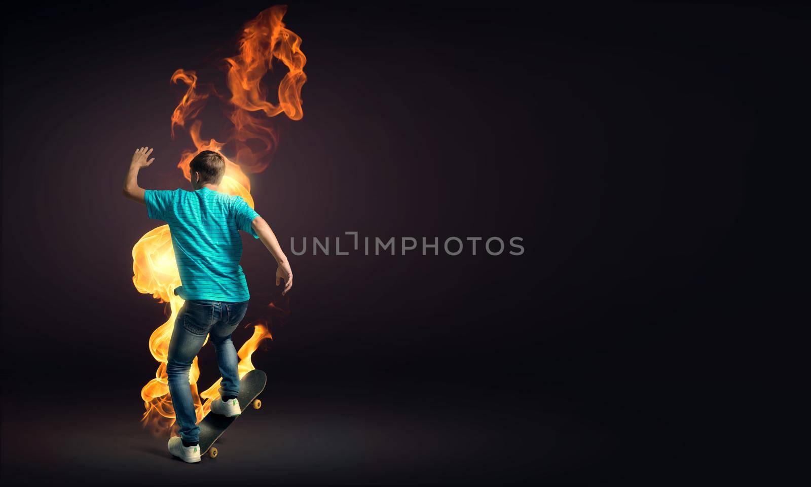 Skater boy riding on his skateboard burning in fire