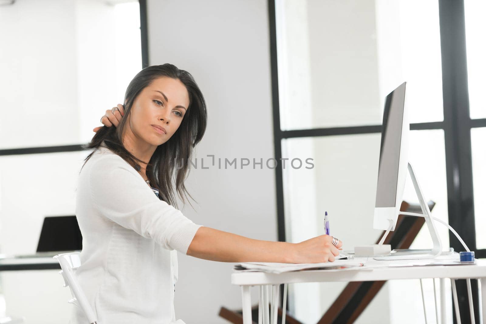 Attractive brunette woman at office desk work on computer