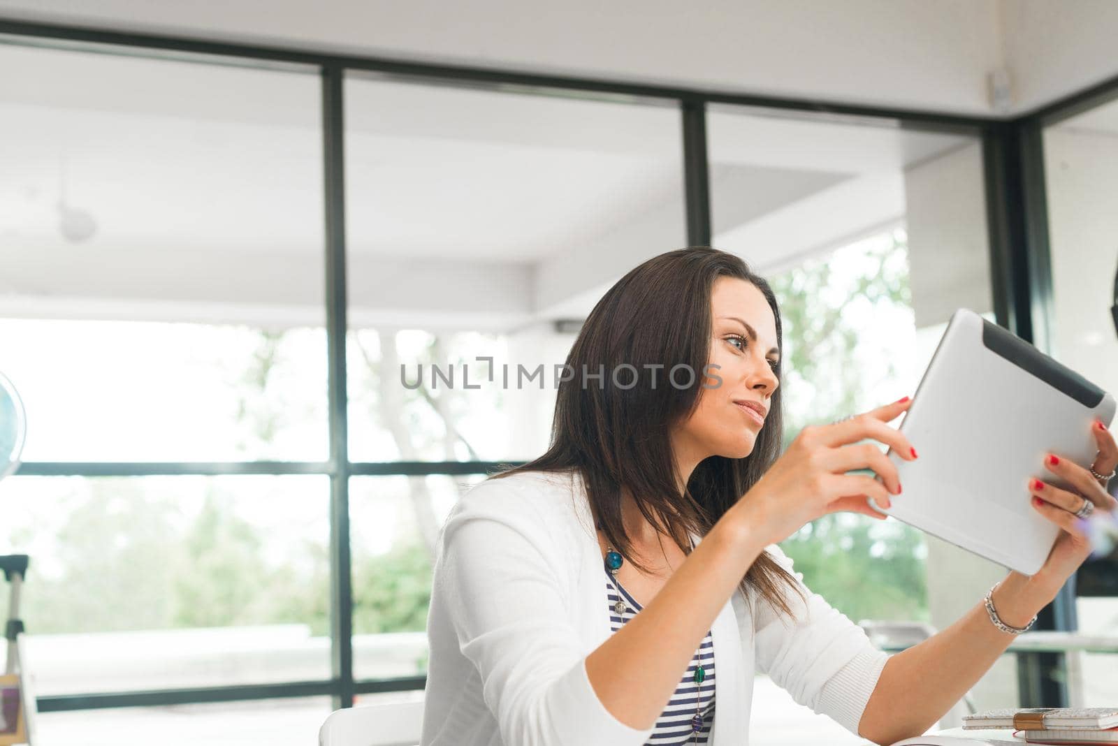 Young attractive brunette working with tablet pc