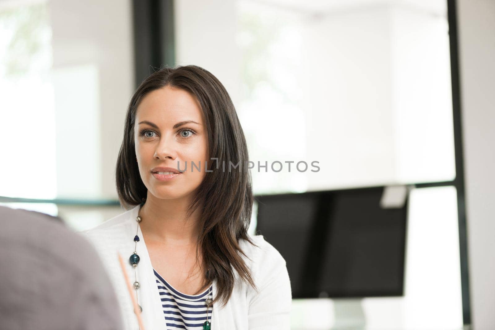 Portrait of pretty brunette woman at desk in office