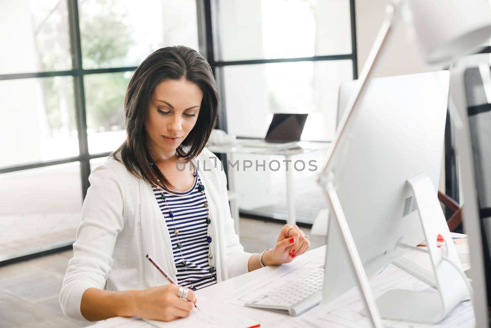 Attractive brunette woman at office desk work on computer