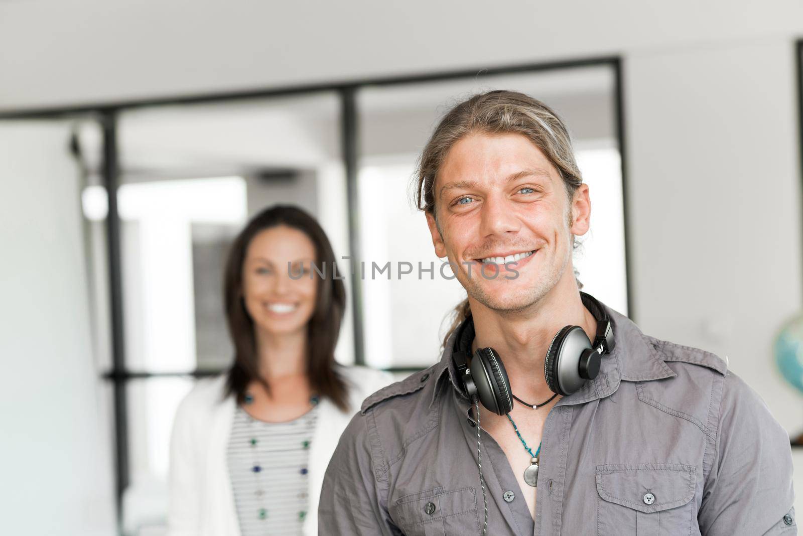 Portrait of young man and woman in bright office