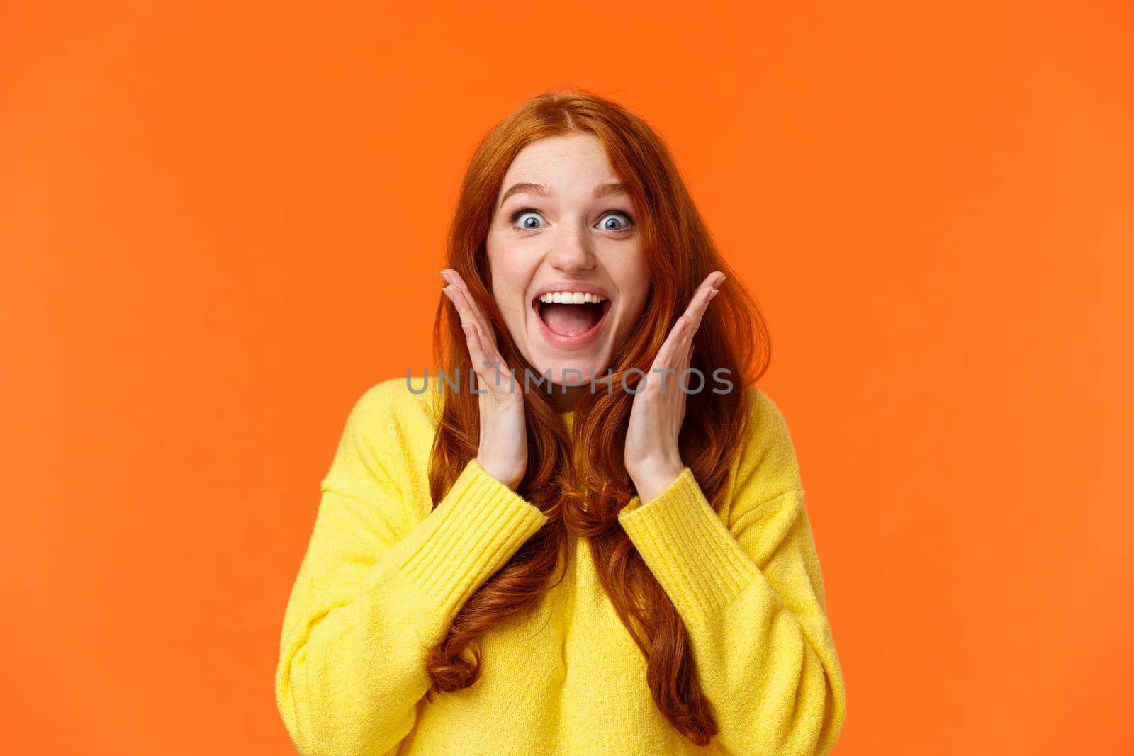 Excitement, emotions and holidays concept. Waist-up shot cheerful impressed and excited redhead woman screaming from thrill and joy, hold hands near face, open mouth and glance amazed by Benzoix