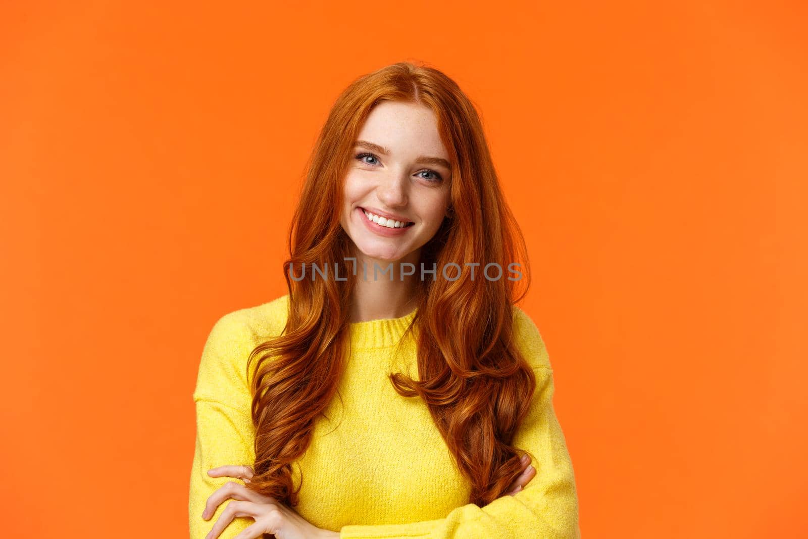 E-commerce, professionalism and employement concept. Cheerful pleasant redhead curly-haired woman in yellow sweater, standing confident with crossed arms and smiling camera.